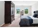 Bright bedroom with two windows, a large wardrobe, and neutral carpet at 1458 Wragby Ln, Apex, NC 27502
