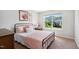 Cozy bedroom with a metal frame bed, soft pink bedding, and a view of the neighborhood at 1458 Wragby Ln, Apex, NC 27502