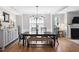 Bright dining room with a black dining set, bench seating, and a stylish white sideboard for storage at 1458 Wragby Ln, Apex, NC 27502
