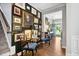 Inviting hallway with hardwood floors, decorative wall art, and an open doorway to the exterior at 1458 Wragby Ln, Apex, NC 27502