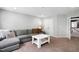 Comfortable living room featuring a gray sectional, a center table, and neutral carpet at 1458 Wragby Ln, Apex, NC 27502