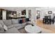 Open-concept living room with a gray sectional, leading to the kitchen and dining area for seamless entertaining at 1458 Wragby Ln, Apex, NC 27502