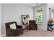 Cozy living room with two plush armchairs, side table, and window with backyard view at 1458 Wragby Ln, Apex, NC 27502