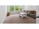 Cozy living room with large windows, a gray sectional, and neutral walls at 1458 Wragby Ln, Apex, NC 27502
