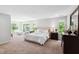 Bright main bedroom with large windows, a plush bed, and classic furnishings at 1458 Wragby Ln, Apex, NC 27502