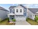 Charming two-story home featuring blue siding, white trim, a two-car garage, and manicured landscaping at 159 Wood Orchid Ln, Garner, NC 27529
