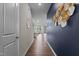 Hallway with wood floors leading to a dining and living area, with modern decor and a blue accent wall at 159 Wood Orchid Ln, Garner, NC 27529