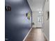 Hallway with wood floors, dark blue accent wall, and decorated with a gold decorative flower at 159 Wood Orchid Ln, Garner, NC 27529
