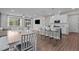 Open-concept living space with a modern kitchen, dining area, and a view to the back porch at 159 Wood Orchid Ln, Garner, NC 27529