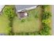 Aerial view of a backyard with a wood deck, umbrella, green grass and mature trees at 19 Arch Oak Ct, Clayton, NC 27527