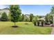 Spacious backyard featuring a lush lawn, mature trees, and a cozy deck with outdoor seating at 19 Arch Oak Ct, Clayton, NC 27527