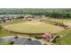 Scenic aerial view of a meticulously maintained baseball field surrounded by a safety fence and newly planted landscaping at 19 Arch Oak Ct, Clayton, NC 27527