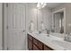 Bathroom featuring double sinks, wood cabinets, and a decorative mirror at 19 Arch Oak Ct, Clayton, NC 27527