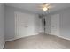 Light gray bedroom featuring wall to wall carpet, a ceiling fan, and 3 closets at 19 Arch Oak Ct, Clayton, NC 27527