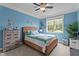 Charming bedroom with woven bed frame, blue accent wall, and natural light at 19 Arch Oak Ct, Clayton, NC 27527