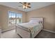 Comfortable bedroom featuring a ceiling fan, large window, and beach-themed bedspread at 19 Arch Oak Ct, Clayton, NC 27527