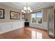 Formal dining room featuring wainscoting, hardwood floors, chandelier, and a large window with blind at 19 Arch Oak Ct, Clayton, NC 27527