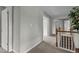Upstairs hallway features neutral paint, carpet flooring, and a staircase with wooden railing at 19 Arch Oak Ct, Clayton, NC 27527