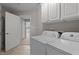 Bright laundry room features a white washer and dryer plus white cabinets for storage at 19 Arch Oak Ct, Clayton, NC 27527