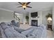 Comfortable living room featuring a large sectional sofa, fireplace, and plenty of natural light from large windows at 19 Arch Oak Ct, Clayton, NC 27527