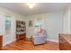Brightly lit bedroom featuring hardwood floors and a cozy chair near the window at 1915 James St, Durham, NC 27707