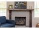 A fireplace with wood mantel, brick surround and hearth, with gas logs insert at 1915 James St, Durham, NC 27707