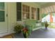 Charming front porch with a green bench, potted flowers, and a welcoming entrance at 1915 James St, Durham, NC 27707