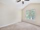 Neutral bedroom featuring a ceiling fan, large window, and plush carpet flooring at 1928 Shadow Glen Dr, Raleigh, NC 27604