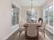 Elegant dining room with large windows, stylish chairs, and a wood table set for six at 1928 Shadow Glen Dr, Raleigh, NC 27604