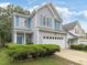 Charming two-story home with gray siding, white trim, blue shutters, and a two-car garage at 1928 Shadow Glen Dr, Raleigh, NC 27604