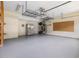 Spacious garage with painted floors, overhead storage and stainless steel refrigerator at 1928 Shadow Glen Dr, Raleigh, NC 27604