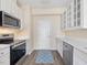 Bright kitchen features white cabinets, stainless steel appliances, and a blue patterned rug at 1928 Shadow Glen Dr, Raleigh, NC 27604