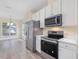 Light-filled kitchen with stainless steel appliances, white cabinets, and an adjacent dining area at 1928 Shadow Glen Dr, Raleigh, NC 27604