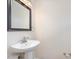 Elegant powder room with a pedestal sink and decorative mirror at 1928 Shadow Glen Dr, Raleigh, NC 27604