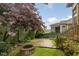 Landscaped backyard features a stone firepit, a beautiful tree, and a brick pathway at 1930 Briar Chapel Pkwy, Chapel Hill, NC 27516