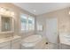 Bright bathroom with marble-lined tub, vanity, and window at 1930 Briar Chapel Pkwy, Chapel Hill, NC 27516