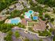 Aerial view of community pools with water slides, mature trees and parking at 1930 Briar Chapel Pkwy, Chapel Hill, NC 27516