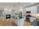 Spacious kitchen with stainless appliances, white cabinets, black countertops, and a cozy fireplace at 1930 Briar Chapel Pkwy, Chapel Hill, NC 27516
