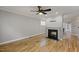 Bright living room featuring hardwood floors, a ceiling fan, and a fireplace at 1930 Briar Chapel Pkwy, Chapel Hill, NC 27516
