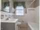 Traditional bathroom with white tile, classic fixtures, and window at 1930 Reid St, Raleigh, NC 27608