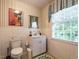 Bright bathroom with modern vanity, playful cat artwork, and window with natural light at 1930 Reid St, Raleigh, NC 27608