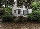 Charming white brick home featuring a quaint front porch with black railing and a welcoming American flag at 1930 Reid St, Raleigh, NC 27608