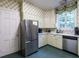 Traditional kitchen features stainless steel appliances, green cabinets, and patterned wallpaper at 1930 Reid St, Raleigh, NC 27608