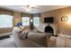 Cozy living room featuring a decorative fireplace, neutral sofa, and multiple windows at 1930 Reid St, Raleigh, NC 27608