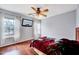 Bedroom featuring wood floors, a ceiling fan, two windows with coverings and a flat-screen television at 2 Donnelly Ct, Durham, NC 27713