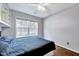 Cozy bedroom with hardwood floors, built-in shelving, ceiling fan, and a large window at 2 Donnelly Ct, Durham, NC 27713