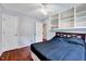 Inviting bedroom featuring hardwood floors, built-in shelving, and natural light at 2 Donnelly Ct, Durham, NC 27713