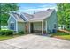 Well-maintained home with green siding, a side driveway, and mature trees around the property at 2 Donnelly Ct, Durham, NC 27713