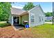 Side exterior showcasing the home's siding, windows, small patio, and grill at 2 Donnelly Ct, Durham, NC 27713