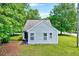Side of the house with large windows and well maintained lawn with shrubs and green grass at 2 Donnelly Ct, Durham, NC 27713